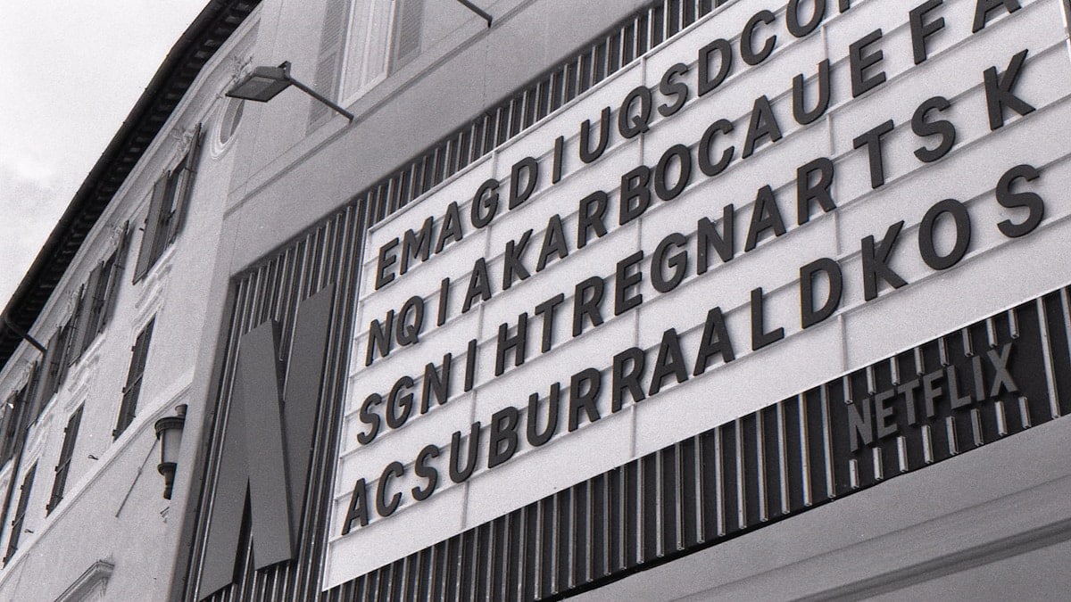 Monochrome building with a netflix sign and scrambled letters.